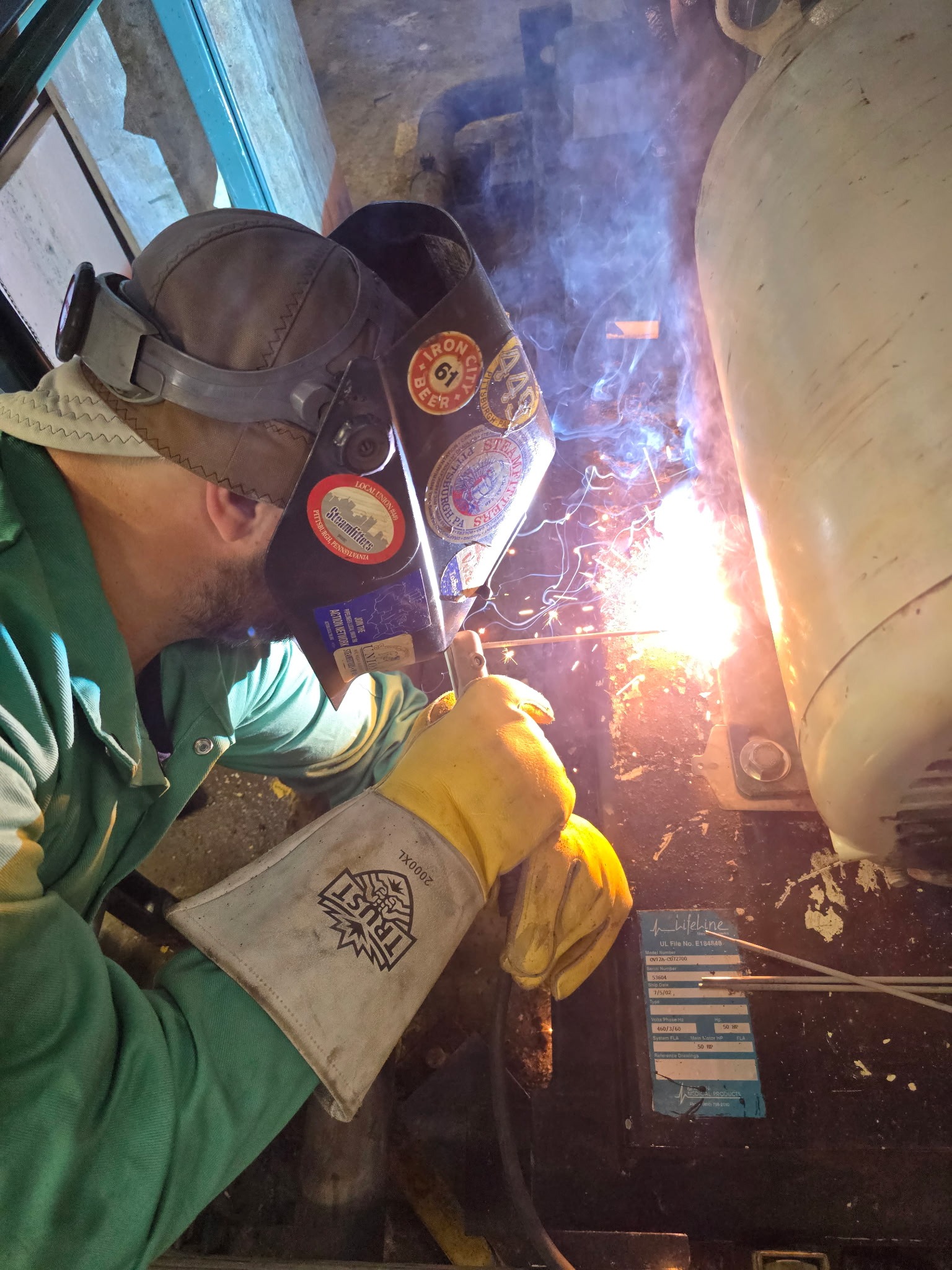 QMS tech torch-cutting galled bolts to remove a seized flange.