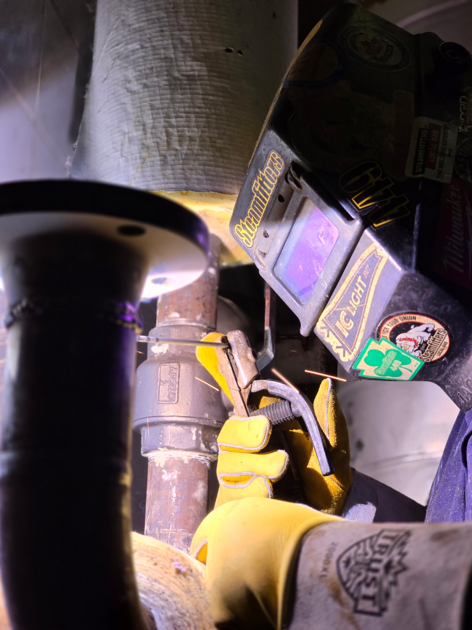 QMS welder tacking a spacer plate into position to correct alignment.